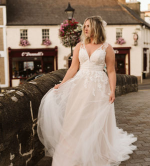 Bride walks along bride in Westport Ireland wearing a tulle and lace wedding dress with lace straps