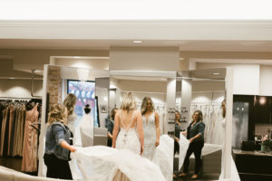bridal consultant fluffs the train of a bride's wedding dress